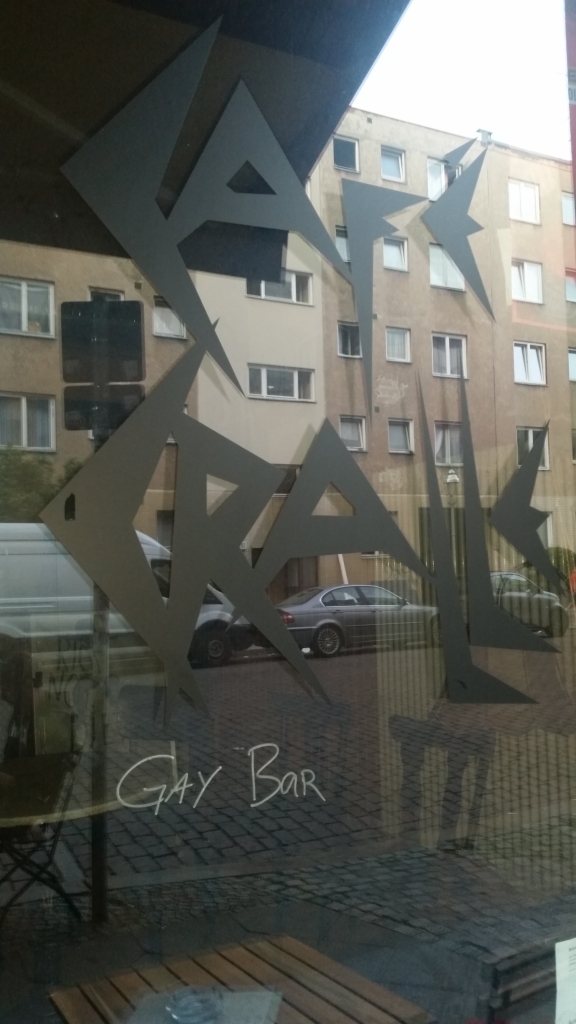 Fensterscheibe mit Cralle-Logo, darunter wurde gay bar gekritzelt.